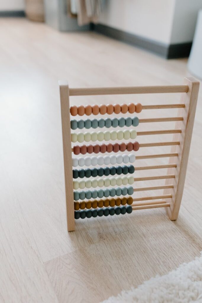 A colorful wooden abacus sitting on a wooden floor, ideal for learning and education themes.