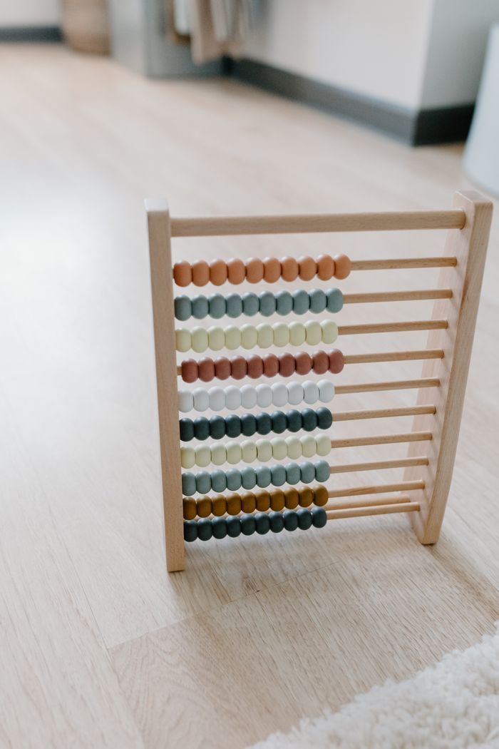 A colorful wooden abacus sitting on a wooden floor, ideal for learning and education themes.